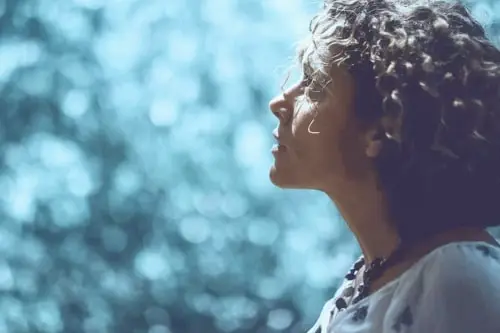 Woman in quiet reflection with soft natural light